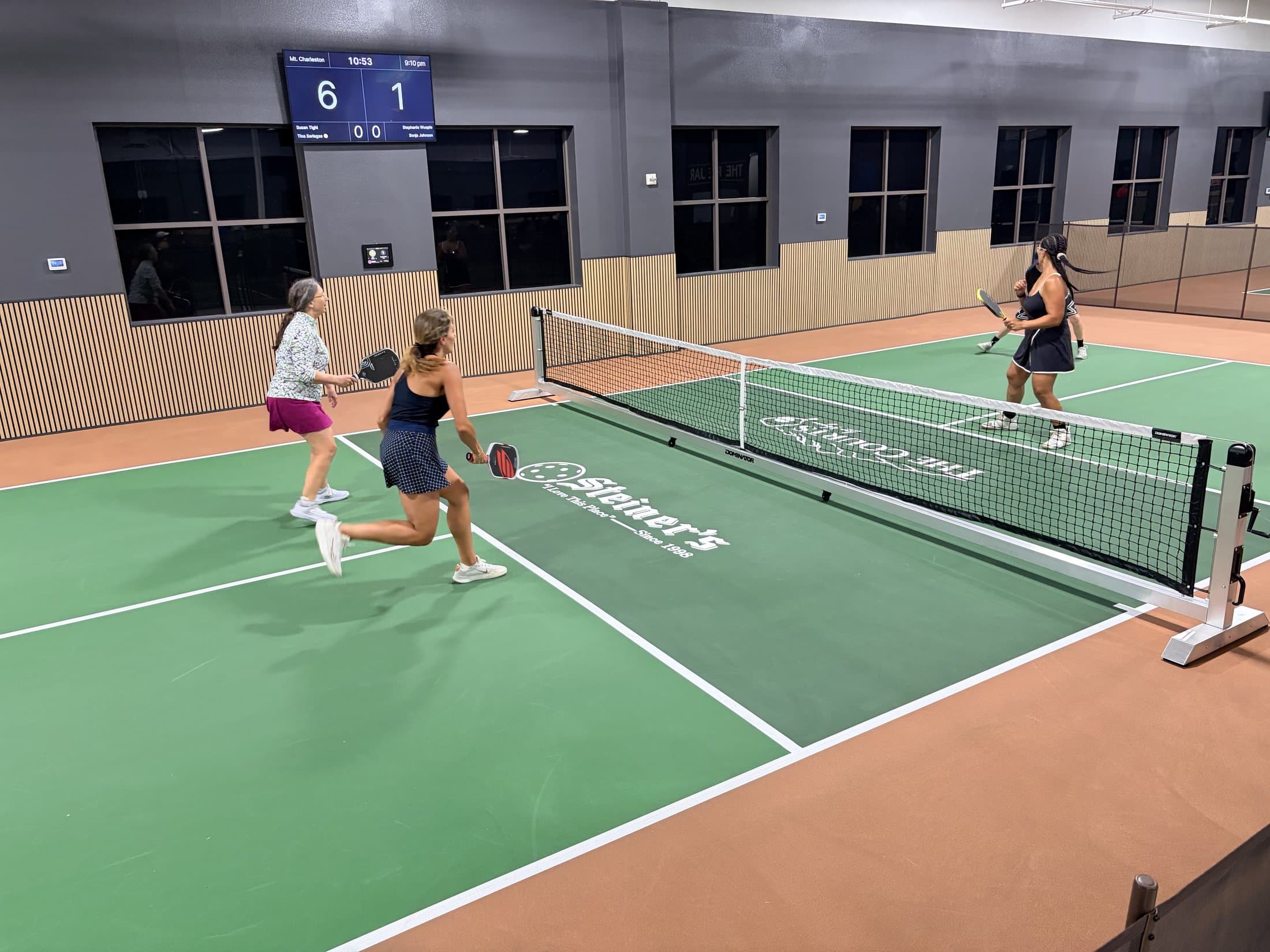 Players training on a green indoor pickleball court at The Courts LV